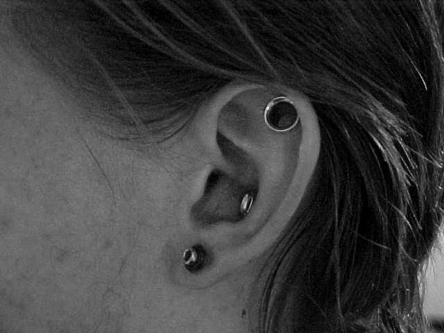 Stretched Lobe And Outer Conch Piercing On Left Ear