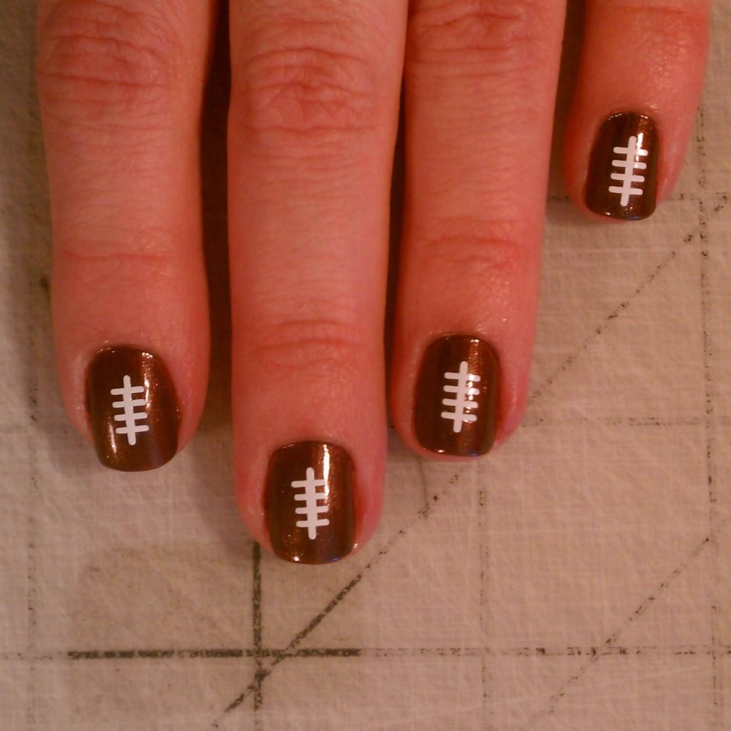 White Football Threads On Brown Nails