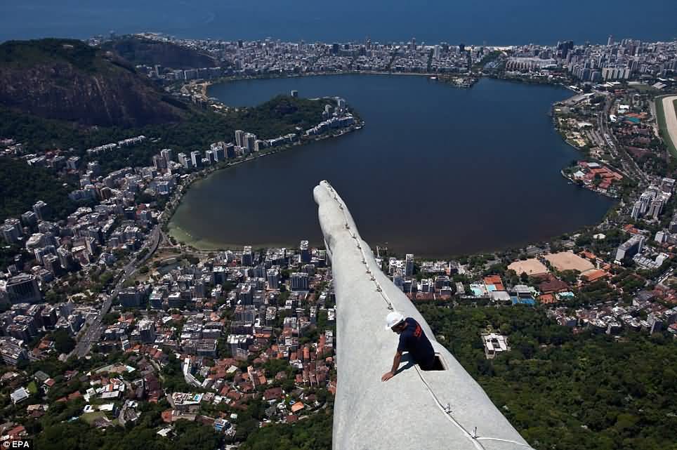 A Construction Worker Can Be Seen On The Arm Of The Christ The Redeemer Statue