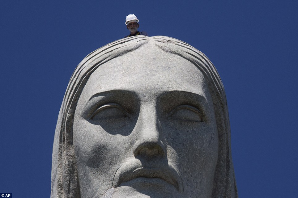 A Repair Worker Examines The Head Of Christ The Redeemer Statue