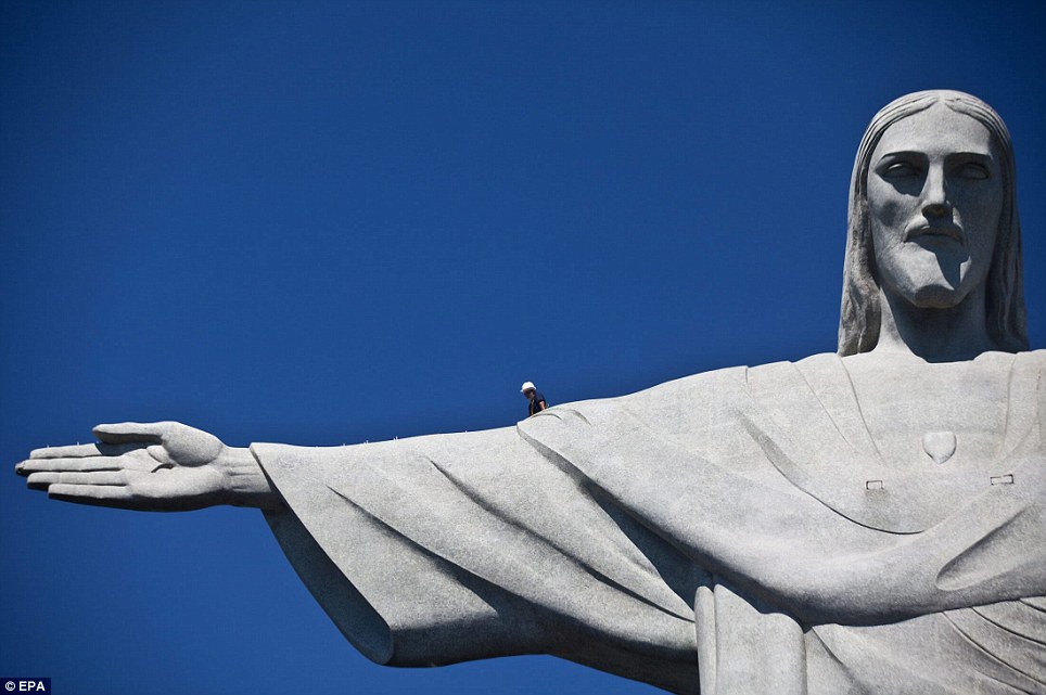 A Worker Walks On An Arm Of Christ The Redeemer In Brazil