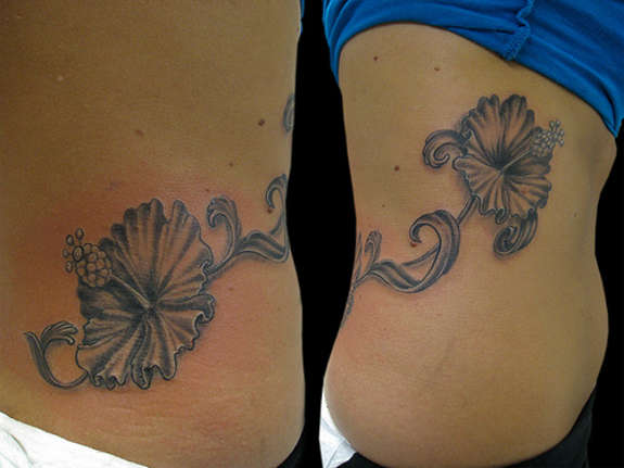 Black And Grey Hibiscus Flower Tattoo On Rib Cage