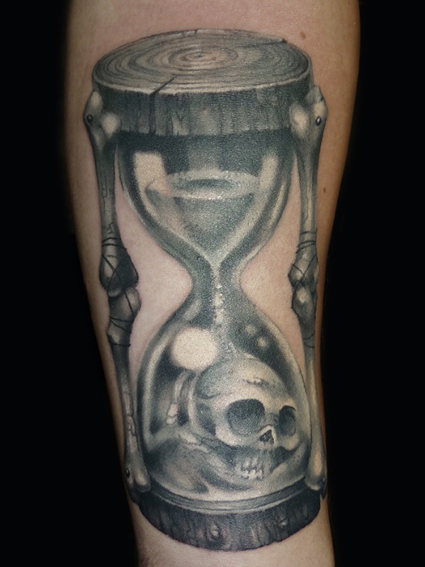 Black And Grey Skull In Hourglass Tattoo On Forearm