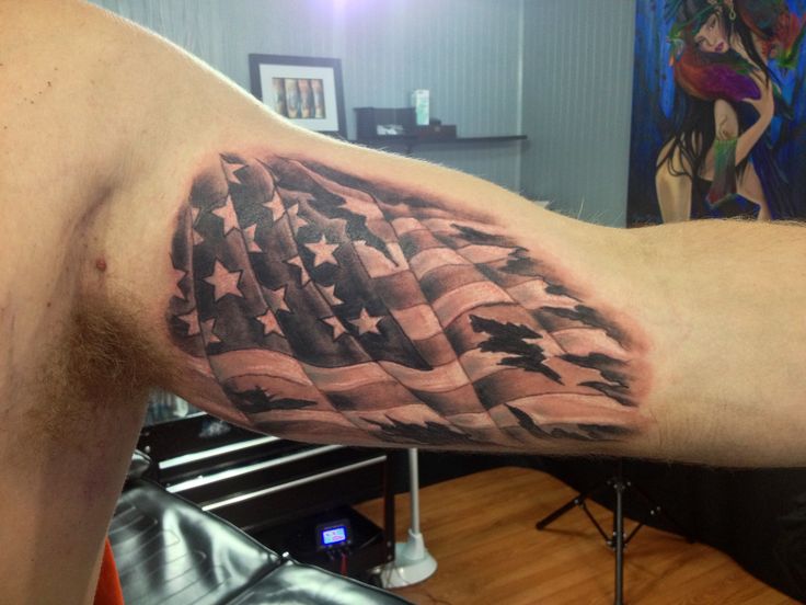 Black And White Torn US Flag Tattoo On Biceps