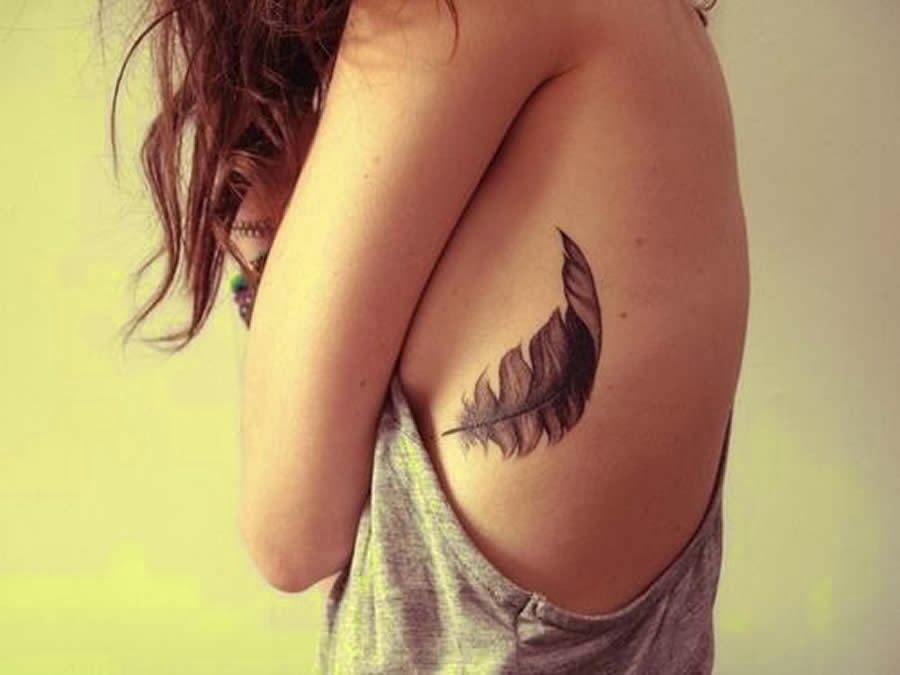 Black Feather Tattoo On Girl Rib Cage