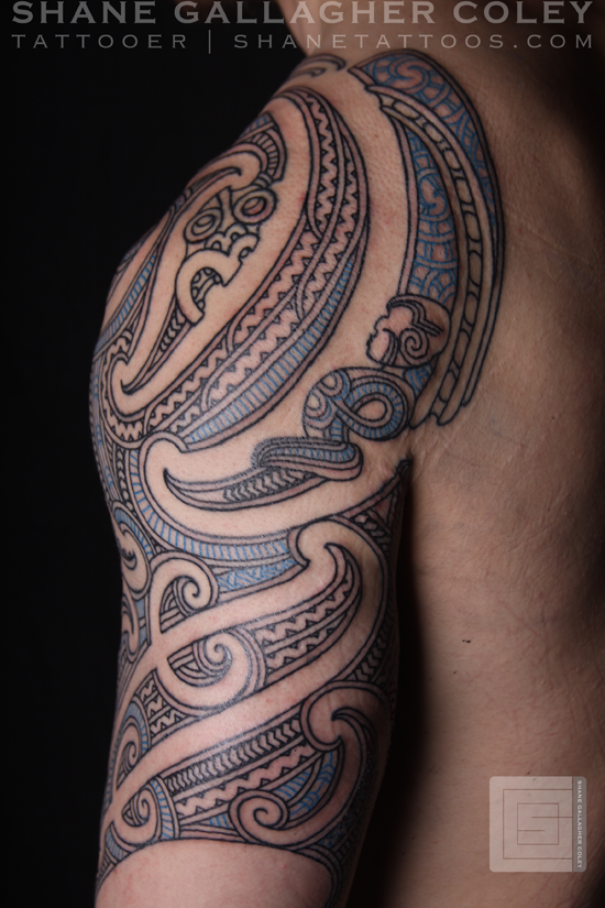 Blue And Black Maori Tattoo On Upper Arm For Men