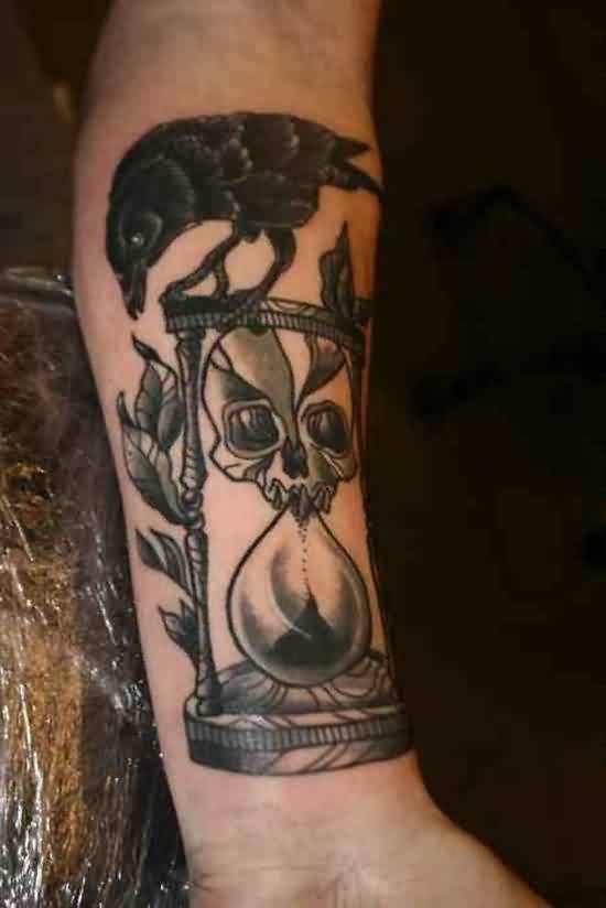 Crow Sitting On Skull Hour Glass Tattoo On Forearm