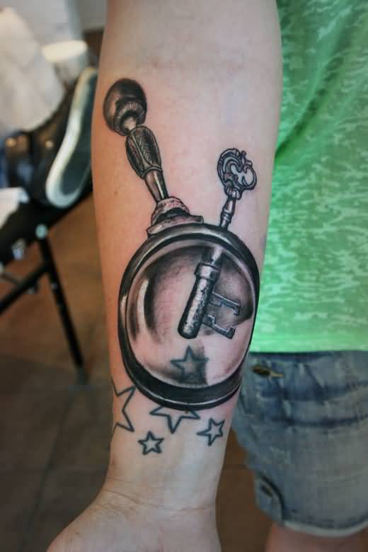 Key And Magnifying Glass Tattoo On Forearm.