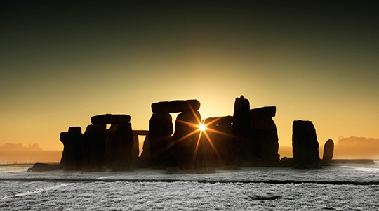 Sun Glinting Through The Stones Of The Stonehenge Monument On A Frosty Morning