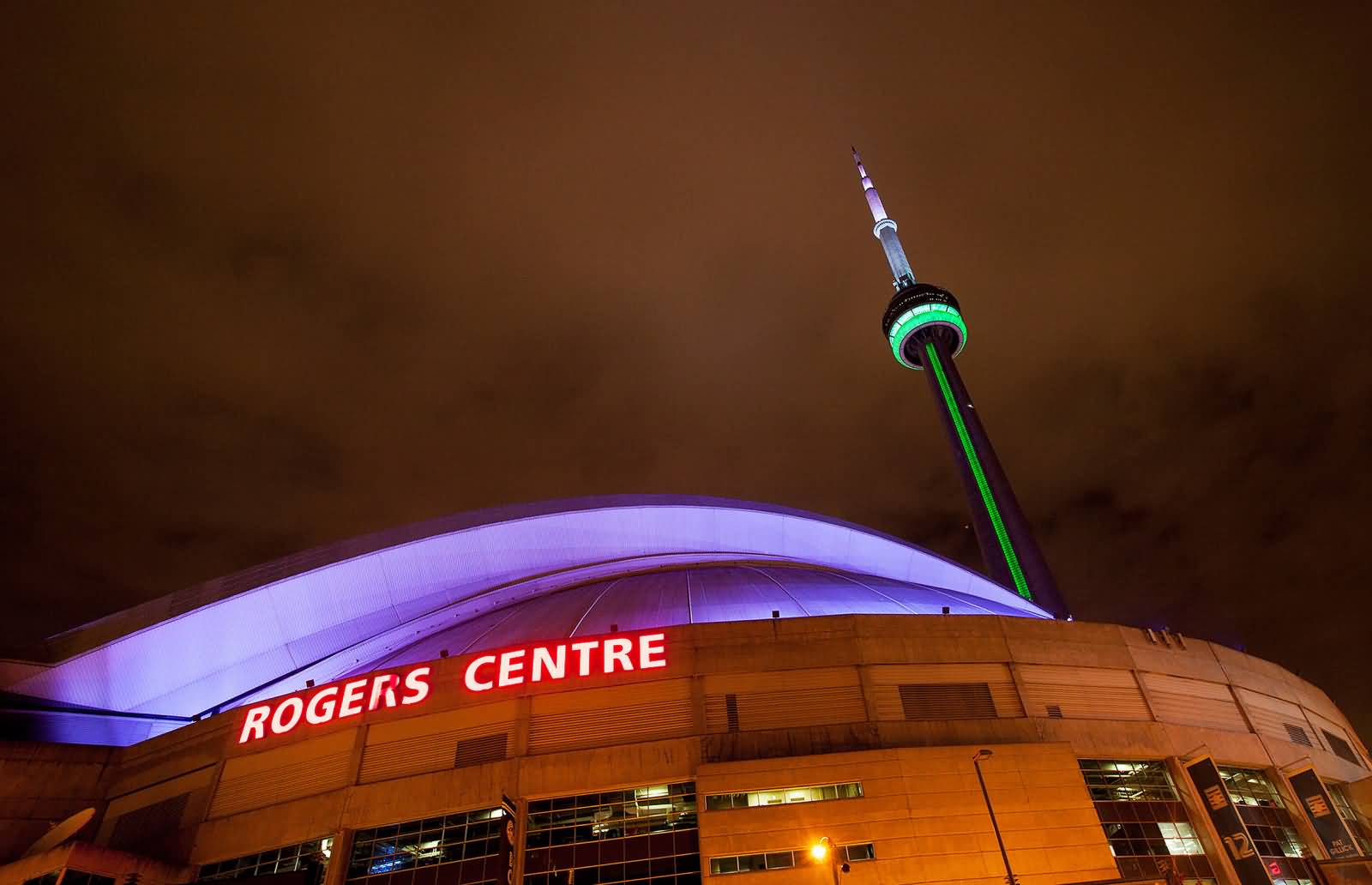 The CN Tower Is Lit In Green And White Colors At Night