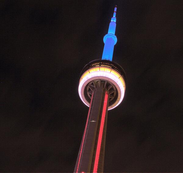The CN Tower Lit Blue, White, Red And Yellow During Night