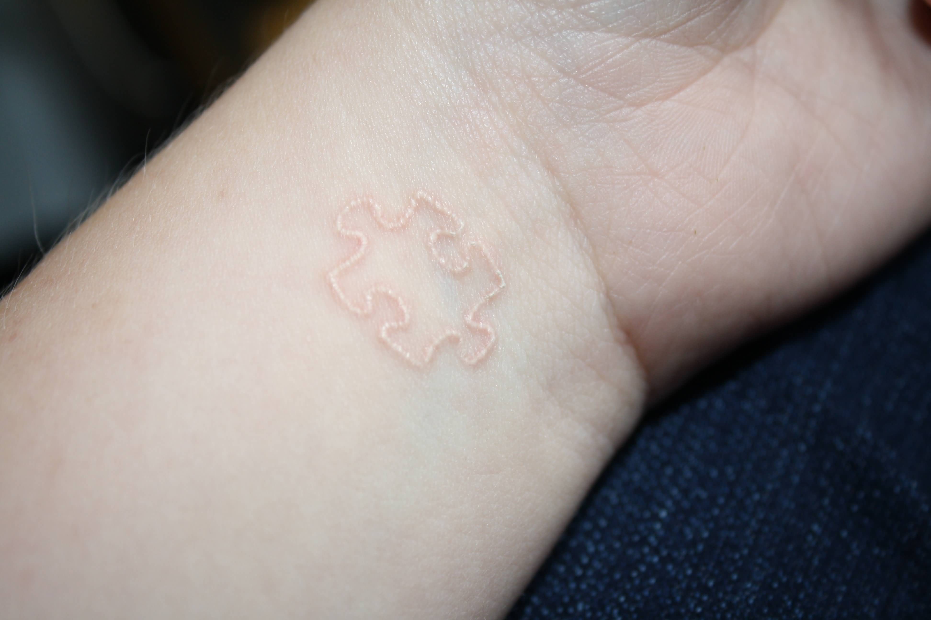 White Ink Puzzle Piece Tattoo On Wrist