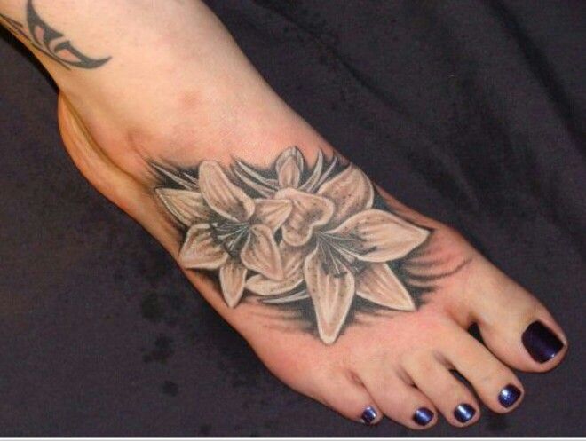 Awesome Black And White Lily Flowers Tattoo On Foot