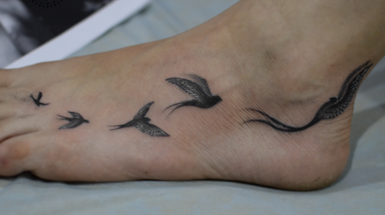 Awesome Flying Black Birds Tattoo On Foot