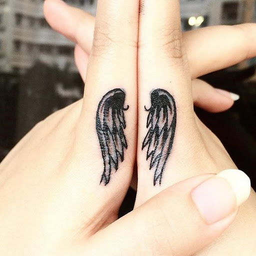 Black And Grey Angel Wings Tattoos On Side Finger