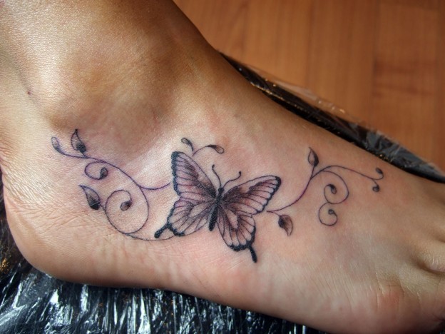 Black And Grey Swirly Butterfly Tattoo On Foot