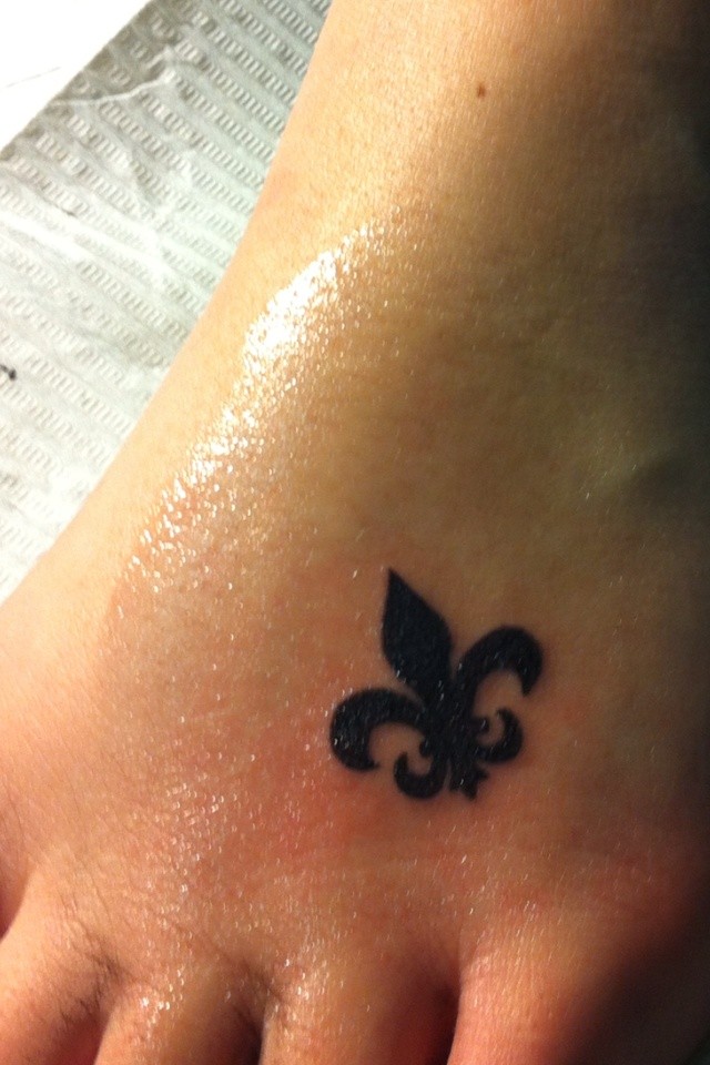 Black Ink Small Fleur De Lis Tattoo On Foot