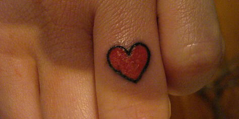Black Outline Red Heart Tattoo On Finger