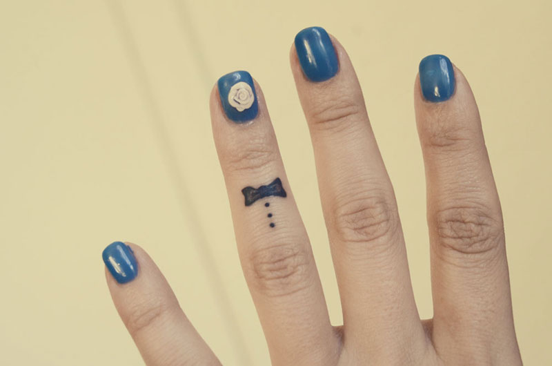 Black Tiny Bow Tattoo On Finger For Girls