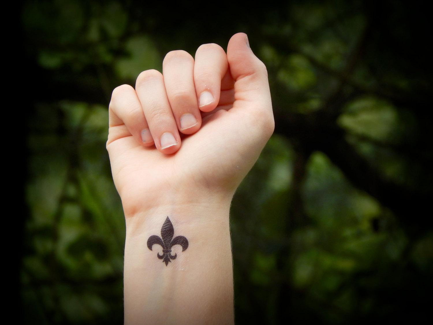 Brown Small Fleur De Lis Tattoo On Wrist.