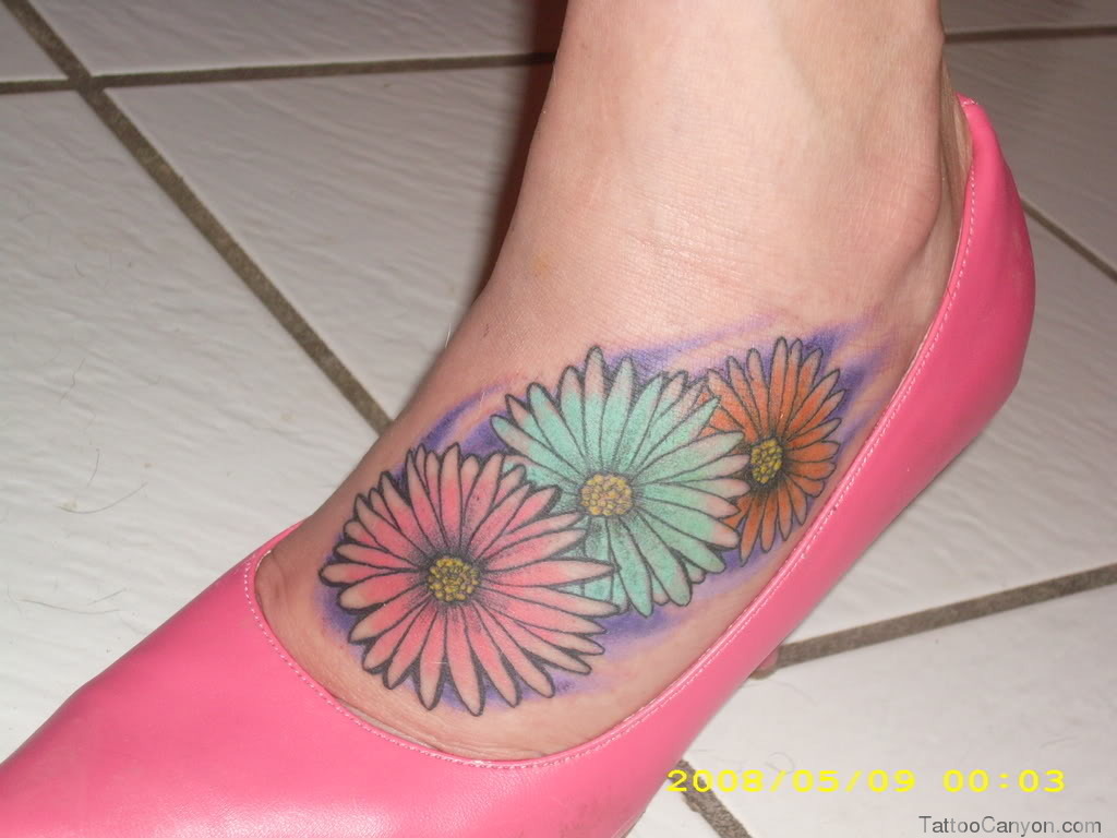 Colored Daisy Flowers Tattoo On Left Foot