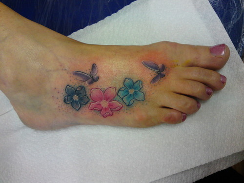 Colorful Flowers With Butterflies Tattoo On Girl Foot