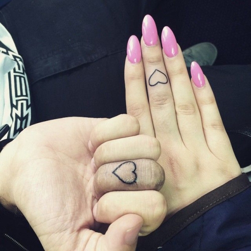 Couple Showing Heart Finger Tattoos