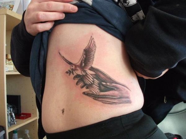 Dove Flying From Hands Tattoo On Side Rib