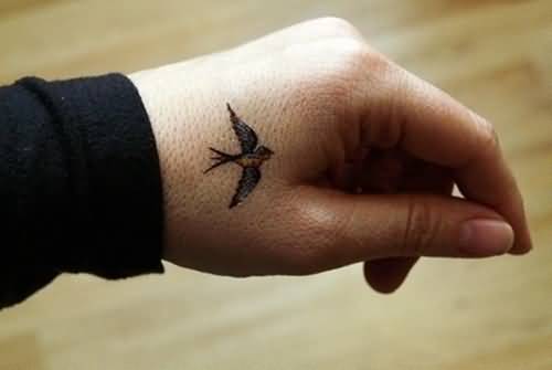 Flying Small Bird Tattoo On Side Hand
