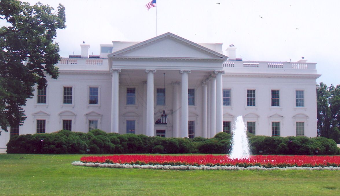 Fountain And Red Poppies On The Front Facade Of White House