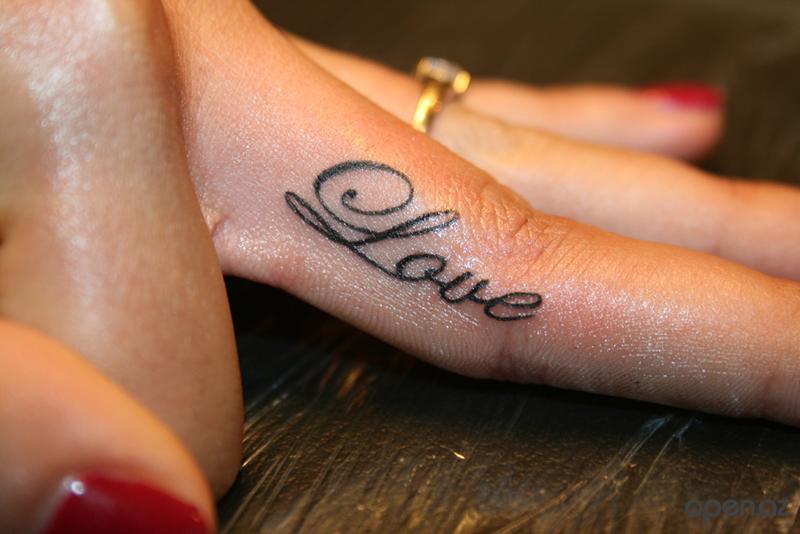 Girl Showing Love Tattoo On Side Finger