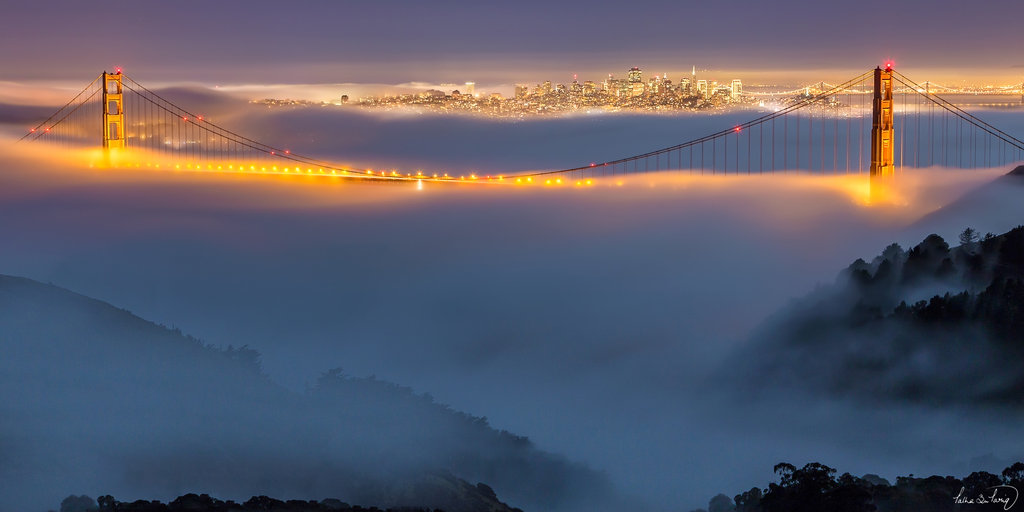 Golden Gate Bridge With Night Lights And Fog Clouds