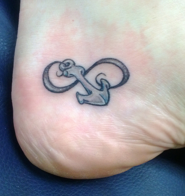 Grey Small Infinity Anchor Tattoo On Foot