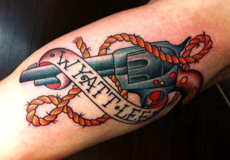 Gun With Rope Tattoo On Bicep