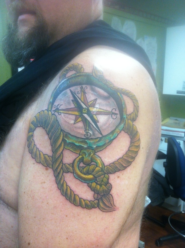 Man Showing His Compass And Rope Tattoo On Left Shoulder