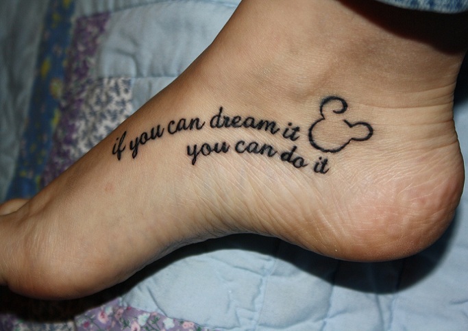 Micky Mouse Head Outline With Quote Tattoo On Foot