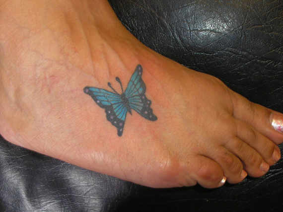 Nice Blue And Black Butterfly Tattoo On Foot