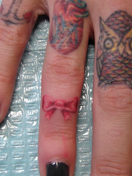Realistic Red Bow Tattoo On Girl Finger By Mario Sanchez