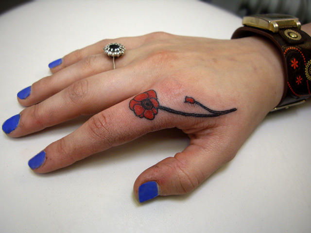 Red Flower Tattoo On Girl Finger