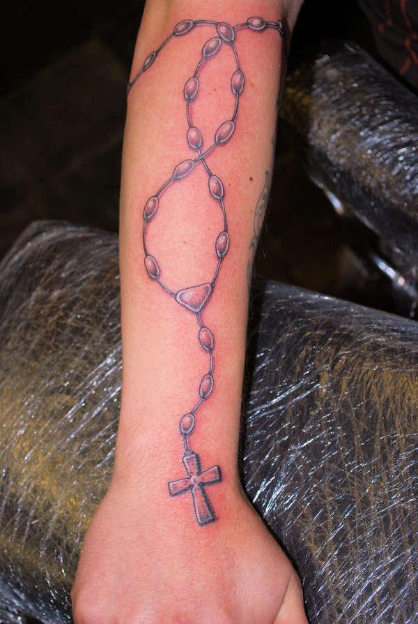 Rosary Spreading On Arm Tattoo