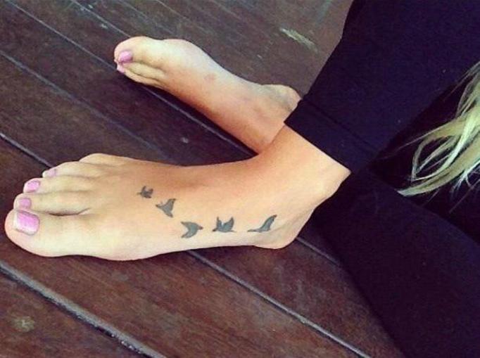 Small Black Birds Flying Tattoo On Girl Foot