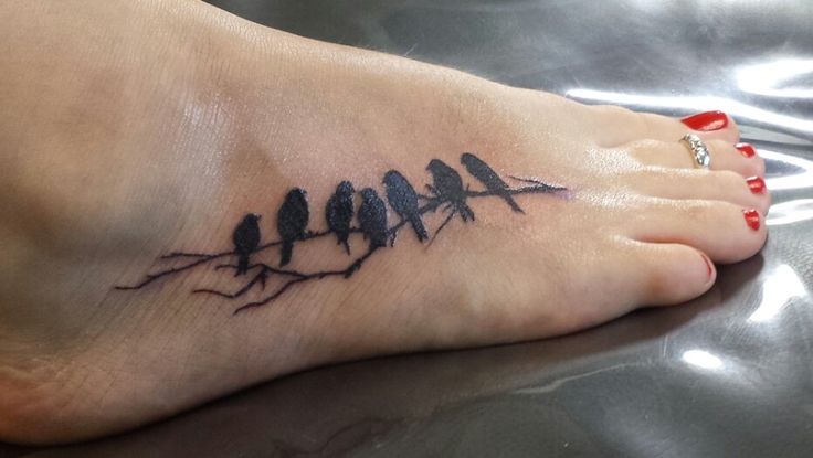 Small Black Group Of Birds On Tree Branch Tattoo On Foot