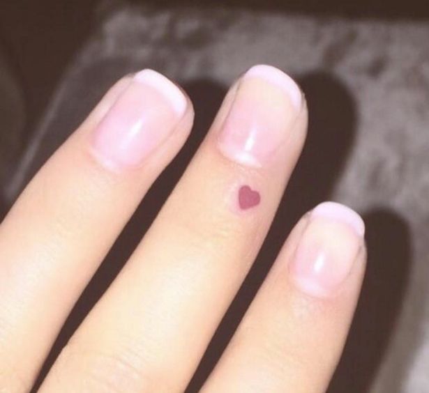 Tiny Pink Heart Tattoo On Girl Finger