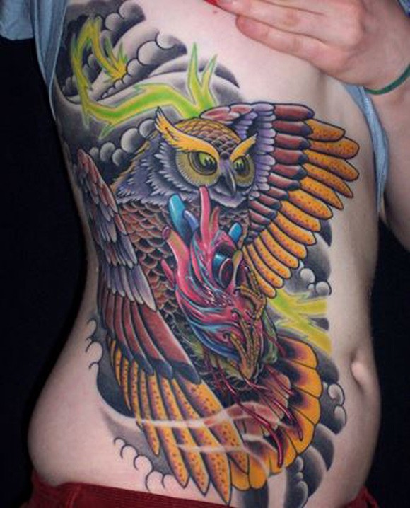 Awesome Flying Owl And Human Heart Tattoo On Side Rib