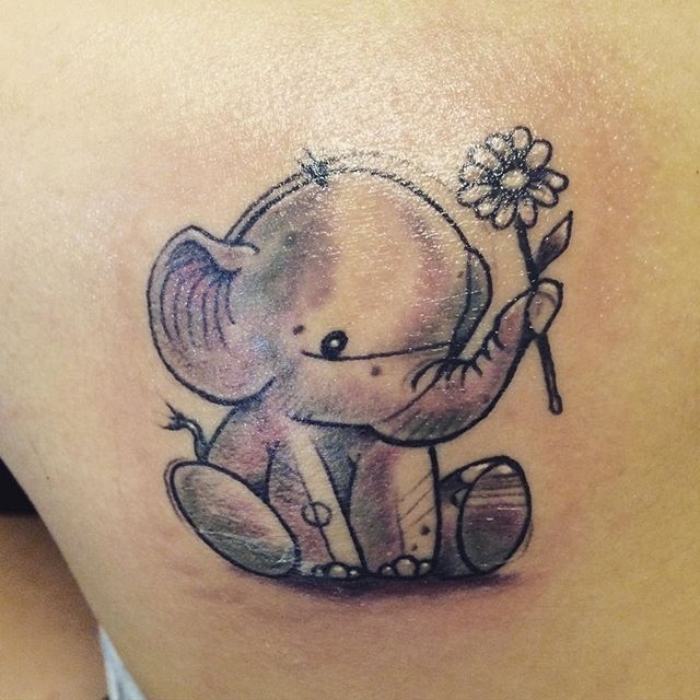 Black And Grey Baby Elephant With Flower Tattoo On Left Back Shoulder