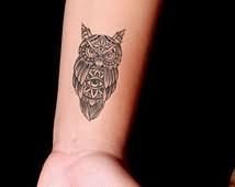 Black Ink Triangle Eye In Owl Tattoo On Wrist