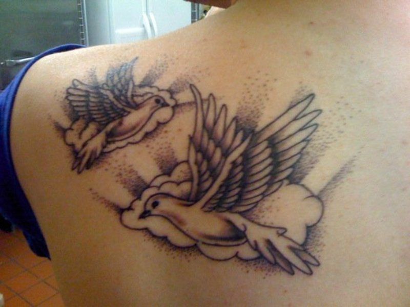 Clouds And Flying Dove Tattoo On Left Back Shoulder.