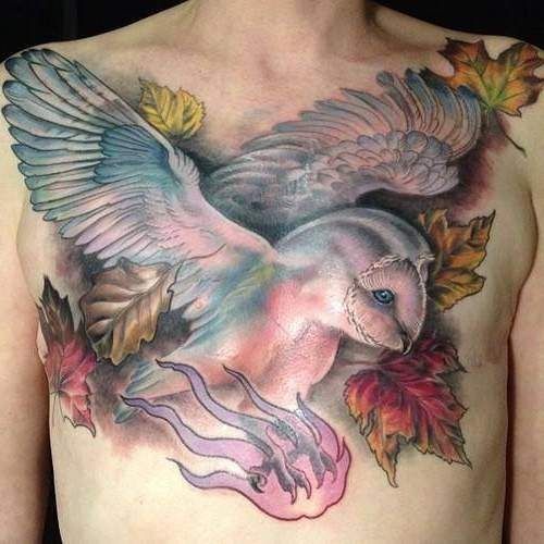 Color Maple Leaves And Flying Owl Tattoo On Man Chest