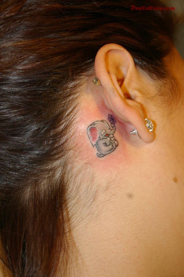 Cute Baby Elephant With Flower Tattoo On Girl Right Behind The Ear