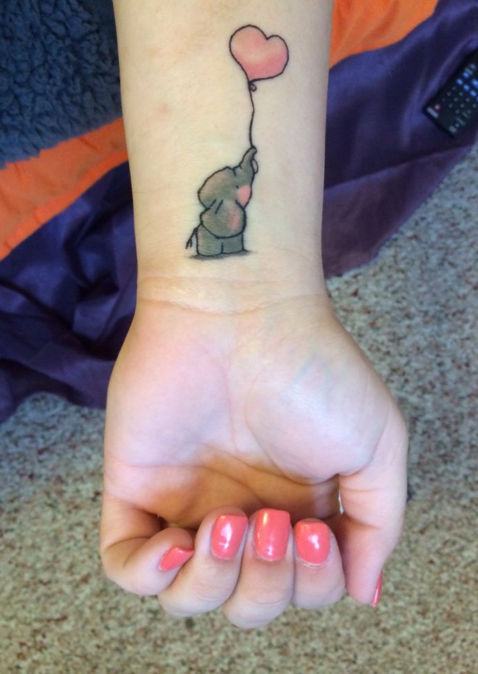 Cute Baby Elephant With Heart Shape Balloon Tattoo On Girl Left Wrist